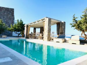 a swimming pool with a gazebo and a swimming pool at Milo Milo Suites in Mandrakia