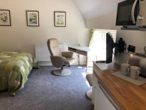 a bedroom with a bed and a desk and a chair at Christmas Hill Farm in Gaydon