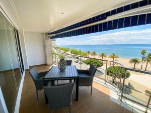 a balcony with a table and chairs and a view of the beach at Roses Casc Antic SL Avda Rodhe in Roses