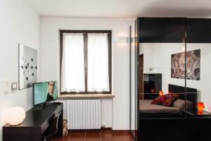 ein Wohnzimmer mit einem Bett, einem Schreibtisch und einem Fenster in der Unterkunft Studio S. Tommaso a Piazza Castello by Wonderful Italy in Turin
