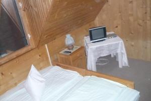 a bedroom with a bed and a desk with a laptop on it at Cabana Dara in Cumpăna