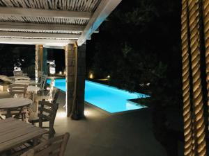 a patio with a swimming pool at night at Milo Milo Suites in Mandrakia
