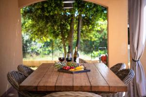 a wooden table with wine bottles and fruit on it at Spacious holiday house - pool / jacuzzi / sauna / playground / 8+2 in Rakalj