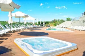 ein großer Pool mit Stühlen und einem Sonnenschirm in der Unterkunft Casa Nicolini in Barbaresco