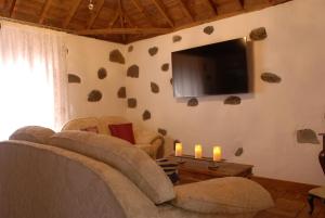 a living room with a couch and a flat screen tv at Casa MARIA in Tazacorte