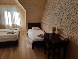 1 dormitorio con 2 camas, escritorio y ventana en Risti kodumajutus en Lemsi