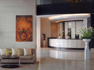 a lobby of a hotel with a couch and a bar at Mövenpick Hotel Jumeirah Lakes Towers Dubai in Dubai