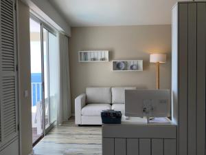 - un salon avec un canapé et un ordinateur sur un bureau dans l'établissement Apartamentos do Mar, à Funchal