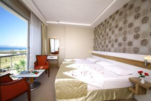 a hotel room with two beds and a large window at Acem Hotel in Ayvalık