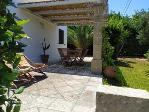 un patio con pérgola, mesa y sillas en Tenuta I Quattro Venti, en Otranto