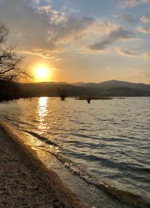 a sunset on the shore of a body of water at Apartmani Pe-Ko in Star Dojran