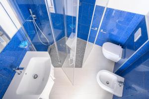 a blue and white bathroom with a toilet and a sink at Hotel Capri 3 Stelle SUPERIOR in Lido di Jesolo
