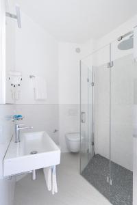 bagno con lavandino e doccia in vetro di Hotel Capri 3 Stelle SUPERIOR a Lido di Jesolo