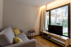 a living room with a couch and a flat screen tv at Sant Pere Homes in Ballestar