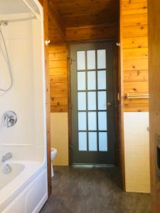 baño con bañera, aseo y puerta en Midnight Sun Vacation Home en Whitehorse