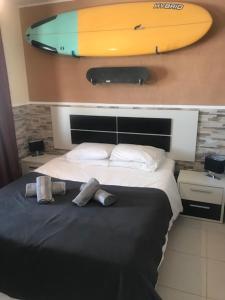 a bedroom with a bed with a surfboard on the wall at Castillo Sun Bungalow in Caleta De Fuste