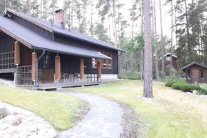 uma cabana de madeira com um caminho à sua frente em Villa Tammio em Uusikaupunki