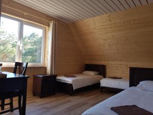 a room with two beds and a desk and a window at Risti kodumajutus in Lemsi