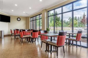 a dining room with tables and chairs and windows at Comfort Inn & Suites Lakewood by JBLM in Lakewood