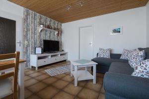 sala de estar con sofá y TV en Ina's Ferienwohnung en Fischbachtal