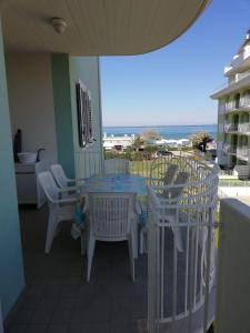 uma mesa e cadeiras numa varanda com o oceano em Appartamento Bellavista em Martinsicuro
