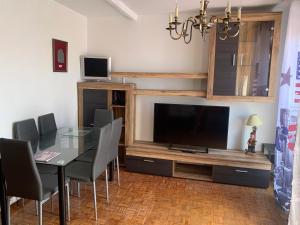 a dining room with a table and a flat screen tv at Apartamento vistas catedral in León