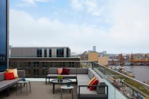 a balcony with couches and tables on a building at Hotel Indigo Berlin - East Side Gallery in Berlin