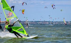 a group of people windsurfing in the ocean at Villa Baltic Chałupy Apartament 11 in Chałupy