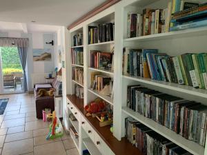 una habitación con varias estanterías llenas de libros en Villa Baltic Chałupy Apartament 11 en Chałupy