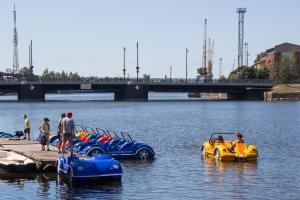 um grupo de pessoas andando em barcos infláveis na água em Hotel Libava em Liepāja