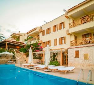 a hotel with a swimming pool in front of a building at Lycia Hotel in Kaş