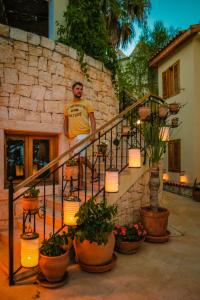 a man standing next to a staircase with potted plants at Lycia Hotel in Kaş