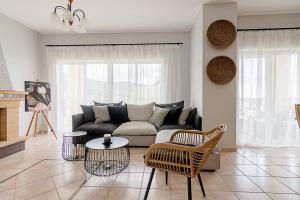 uma sala de estar com um sofá e uma mesa em Theros Premium Villa in Stalis Heraklion em Stalida
