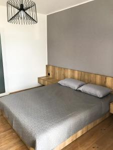 1 dormitorio con 1 cama con cabecero de madera en Sezon en Svityazʼ