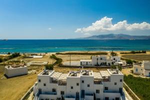 an aerial view of white buildings and the ocean at Salinus Villas in Plaka
