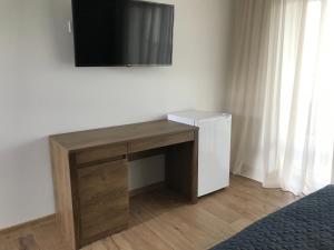 a wooden desk with a television on a wall at Sezon in Svityazʼ