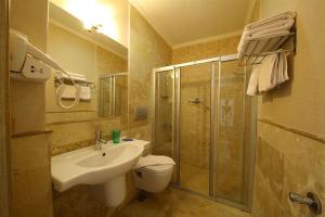 een badkamer met een wastafel en een douche bij Acem Hotel in Ayvalık