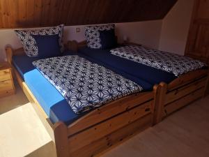 Cama grande de madera con sábanas y almohadas azules en Casa Mosella en Enkirch