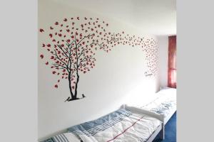 a bedroom with a tree with red leaves on the wall at An den Auwiesen in Kleineicholzheim