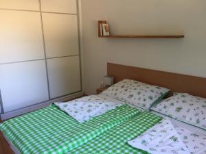 a bed with a green and white sheets and pillows at Apartman U sjezdovky in Velké Karlovice