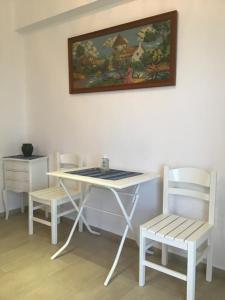 a table and two chairs and a table and a painting at Villa Maria in Kamariotissa
