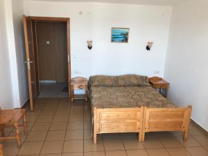 Schlafzimmer mit einem Bett, einem Tisch und einer Tür in der Unterkunft Bisser Obzor in Obsor