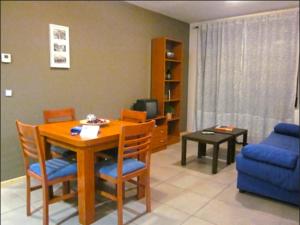 uma sala de estar com uma mesa e um sofá azul em Apartamentos Los Mayos de Albarracín em Albarracín