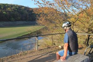 a man sitting on a ledge overlooking a river at BELVEDERE - das BIO HOTEL Garni & SuiteHotel am Edersee ! Unser Geschenk für Sie, auch die GästeCard GrimmHeimat! in Waldeck