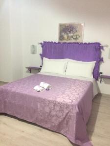 a purple bed with two towels on top of it at Casa Violet per Civita in Bagnoregio