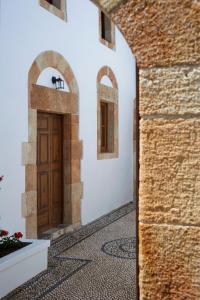 a hallway with a wooden door in a building at Casa Lindos in Lindos