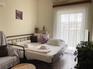 Habitación con cama, sofá y ventana en KROKOS HOUSE, en Aliveri