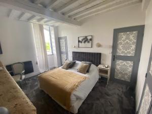 a bedroom with a bed and a desk and a window at Hostellerie Les Griffons in Bourdeilles