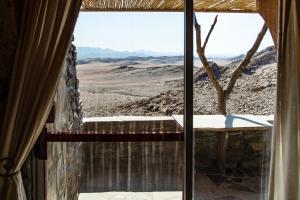 a view of the desert from a window of a house at Rostock Ritz Desert Lodge in Cha-re +43 photos