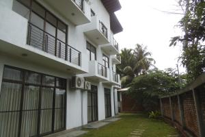 a white building with windows and a fence at ELDORADO RESIDENCY 3 BR BRAND NEW FULLY FURNISHED Apartment in Wattala